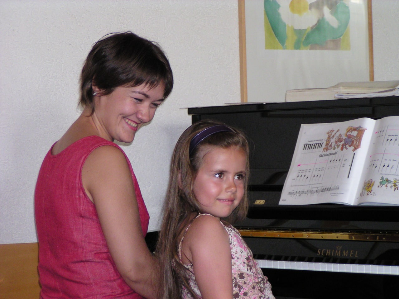 Lehrerin mit Mädchen am Klavier - Musikunterricht in Basel